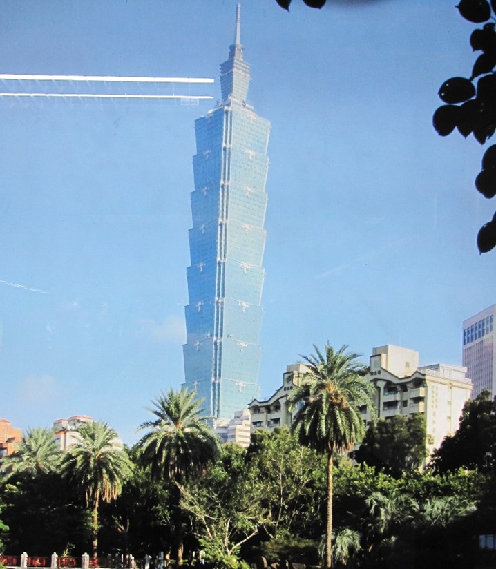 A tall modern building with palm trees in the foreground